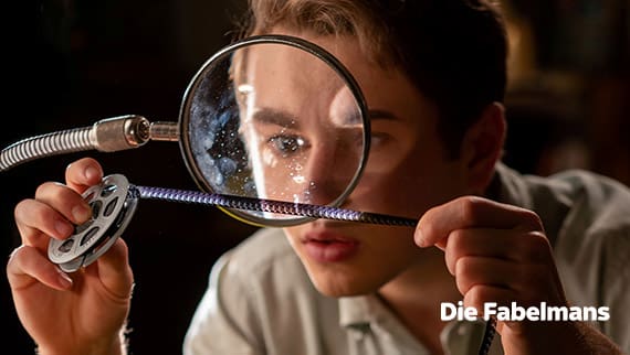 Young man looking at microfiche through a magnifying glass